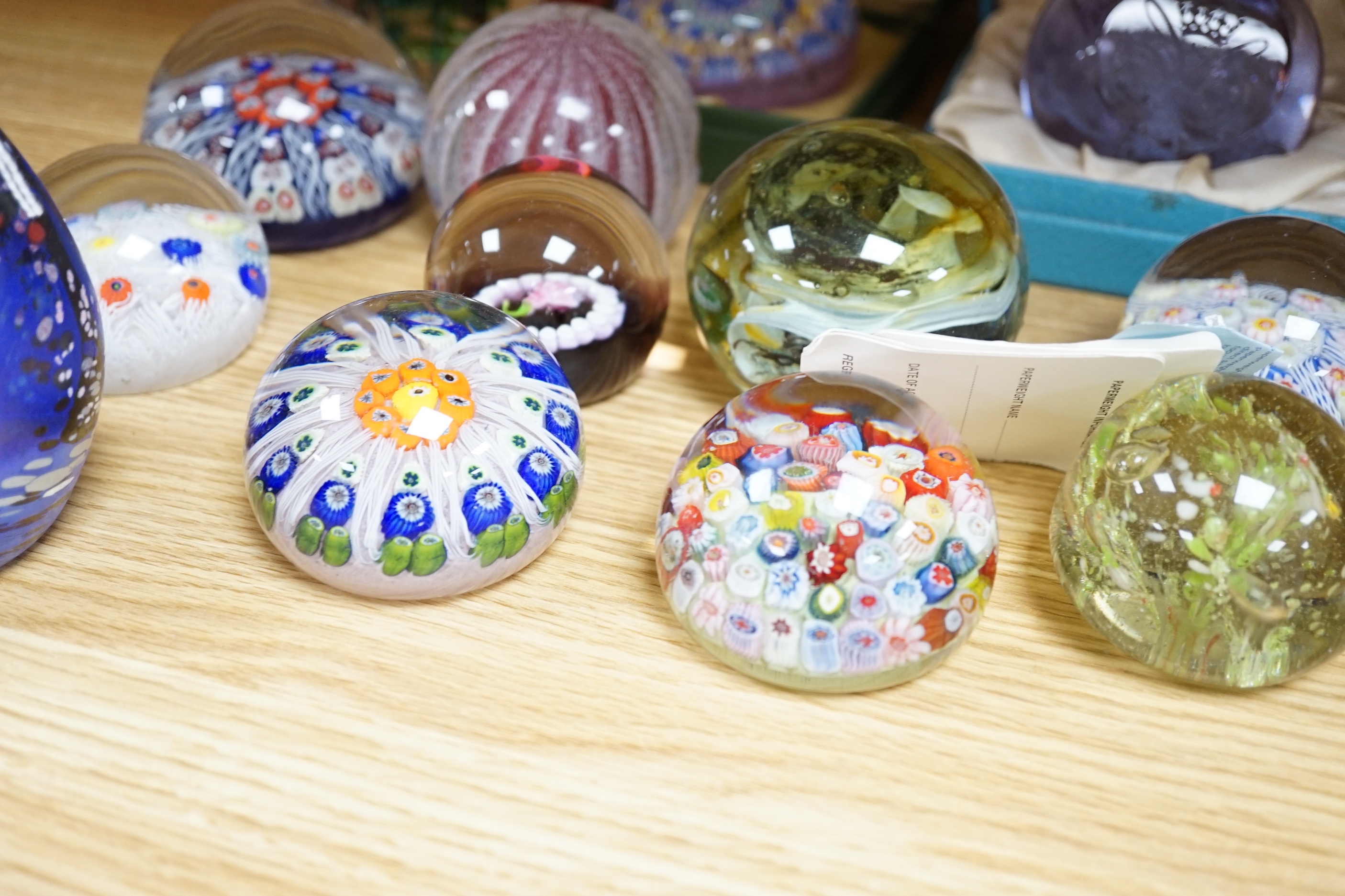 A collection of coloured glass paperweights including Strathearn, Caithness (28)